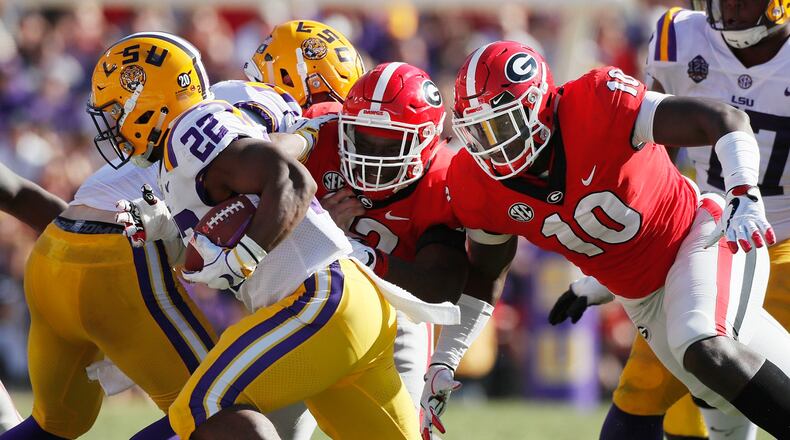 LSU running back Clyde Edwards-Helaire (22) evades Georgia defensive lineman Malik Herring (10) and a teammate Saturday, October 13, 2018, at Tiger Stadium in Baton Rouge, LA. BOB ANDRES / BANDRES@AJC.COM
