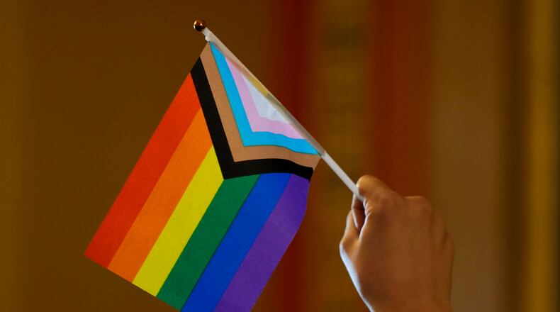 FILE - An LGBTQ+ rights supporter holds a flag in the hallway outside an Iowa House Judiciary subcommittee hearing, Jan. 31, 2024, at the Statehouse, in Des Moines, Iowa. (AP Photo/Charlie Neibergall, File)