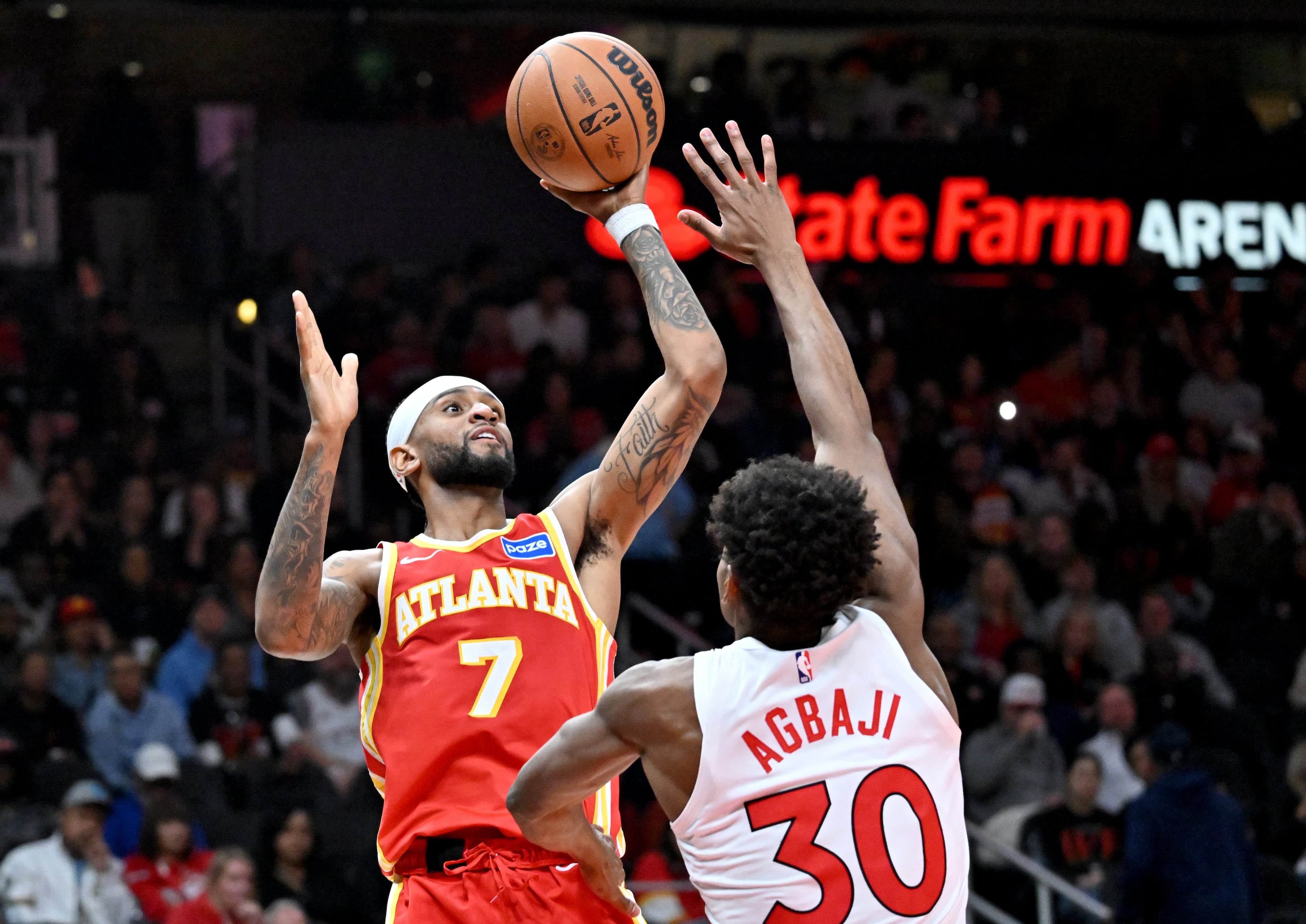 Atlanta Hawks guard Nickeil Alexander-Walker (7) gets off a shot over Toronto Raptors guard Ochai Agbaji (30) during the second half in the home opener at State Farm Arena, Thursday, October 22, 2025, in Atlanta. Toronto Raptors won 138-118 over Atlanta Hawks. (Hyosub Shin / AJC)