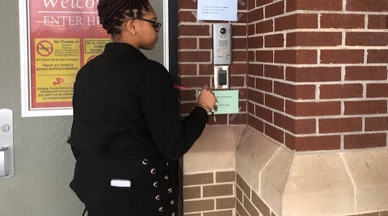 One of the security enhancements added to Douglas County Schools is an access control system that allows administrators to control who can enter a school campus and the hours they have access to the campus. Here, a staffer demonstrates how the the system works. COURTESY OF DOUGLAS COUNTY SCHOOL SYSTEM