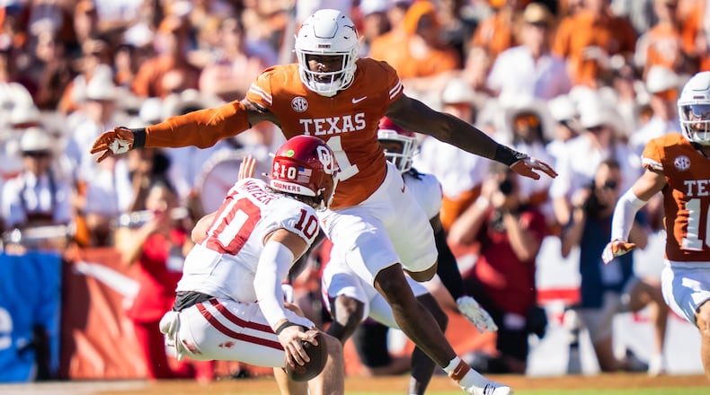 FILE - Texas linebacker Colin Simmons (1) goes to tackle Oklahoma Sooners quarterback John Mateer (10) during the second quarter of an NCAA college football game at the Cotton Bowl in Dallas, Oct. 11, 2025. (Sara Diggins/Austin American-Statesman via AP, File)