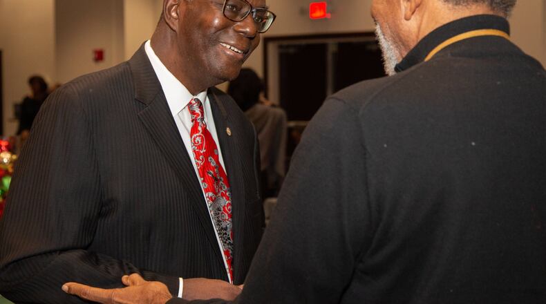 Clark Atlanta University President Ronald A. Johnson (left) talks with Dr Herbert Eichelberger during a holiday party at the Henderson Student Center on campus in Atlanta on Friday, Dec. 7, 2018. Johnson is retiring this month. (Photo by Phil Skinner)