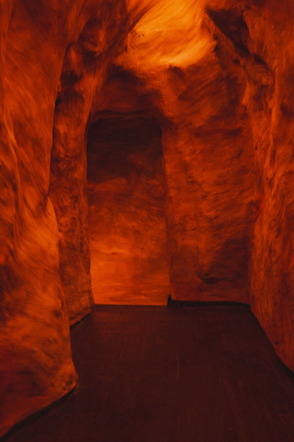 A narrow hallway with stone walls inspired by a slot canyon