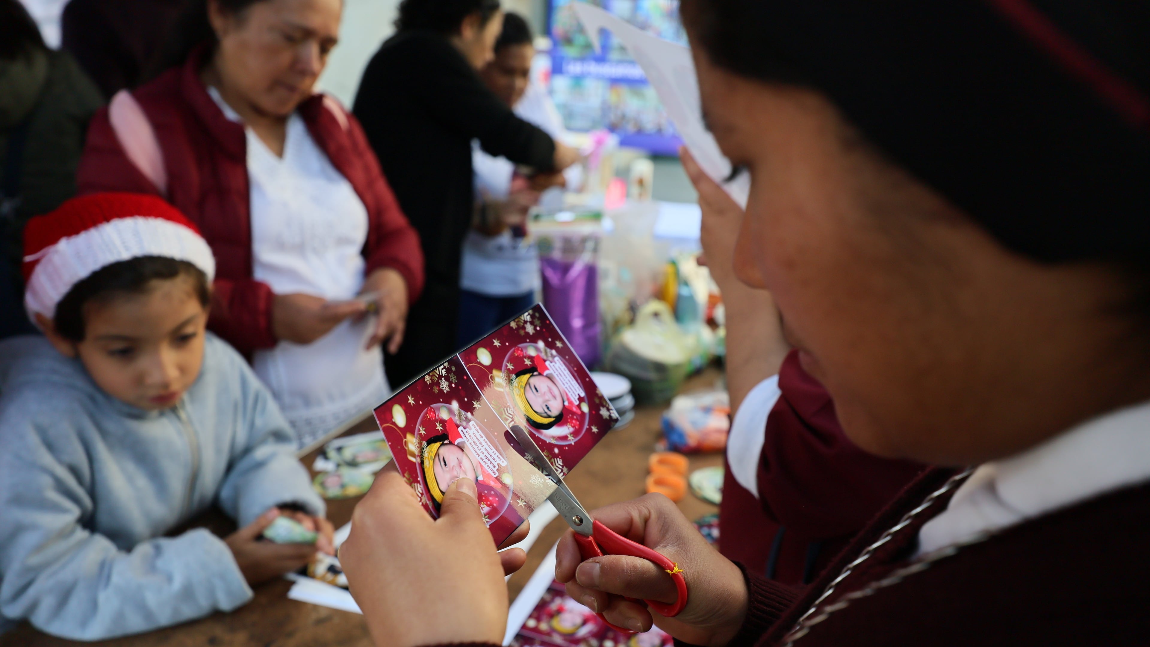 Sister Maria Elena cuts a photograph of a missing girl to paste on a Christmas ornament to hang on the Tree of Hope, during an event organized by the diocese of Ecatepec at the Church of the Sacred Heart of San Cristobal in Ecatepec, State of Mexico, Monday, Nov. 17, 2025. (AP Photo/Ginnette Riquelme)