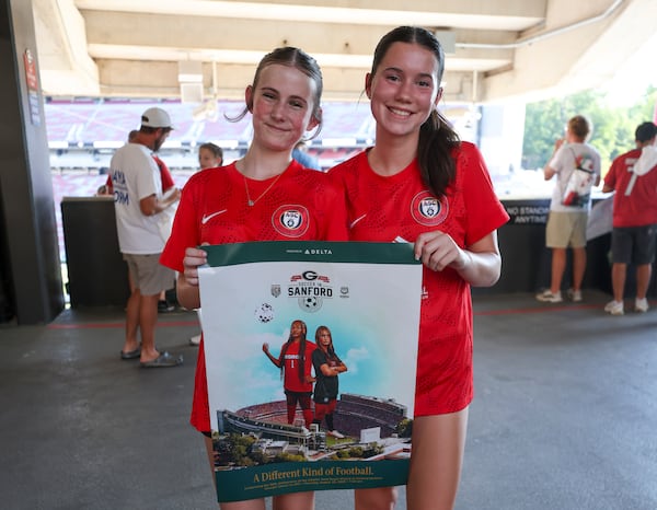 Haley Jones (left) and Colleen Ennis, both 14-year-olds from Jackson County, hold the “Soccer in Sanford” poster before Georgia’s match against James Madison on Thursday, Aug. 20, 2026, in Athens. (Jason Getz/AJC)