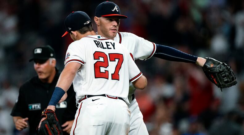 Braves infielders Freddie Freeman (background) and Austin Riley celebrate after the Braves defeated the San Diego Padres Tuesday, July 20, 2021, at Truist Park in Atlanta. (John Bazemore/AP)