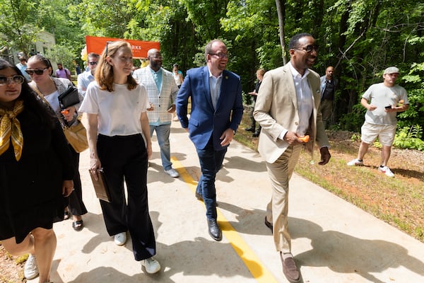 City council member Dustin Hillis (center) and Mayor Andre Dickens (right) walk down the trail at the grand opening at the Woodall Rail Trail in Atlanta on Friday, May 9, 2025. It’s the first completed segment of the Silver Comet connector in the city of Atlanta. (Arvin Temkar/AJC)