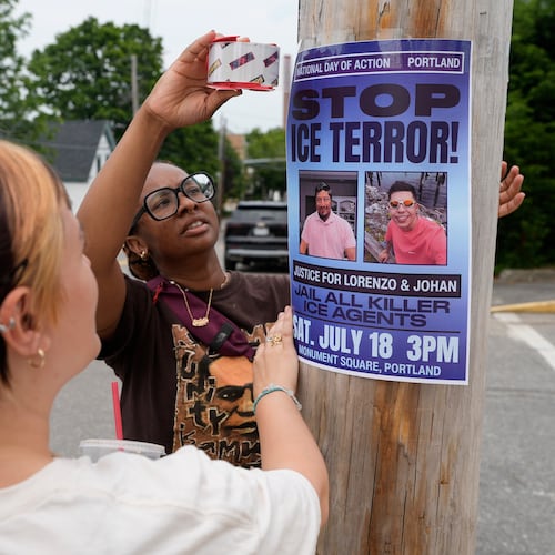 Angeliki Cintron, left, and Saidi Moseley post a notice of an upcoming gathering in response to the recent killings by U.S. Immigration and Customs Enforcement agents, in Biddeford, Maine, Wednesday, July 15 2026. (AP Photo/Robert F. Bukaty)