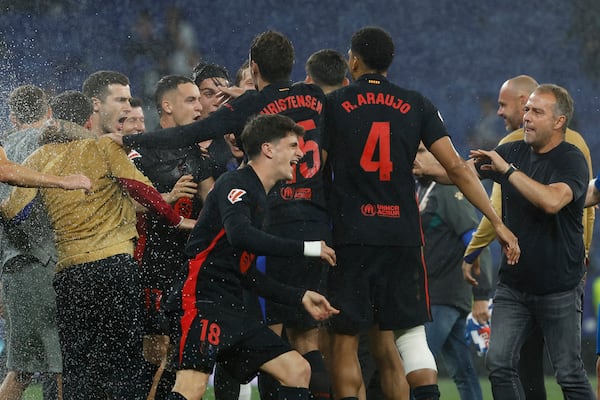 Barcelona players celebrate at the end of the Spanish La Liga soccer match between Barcelona and Espanyol at Lluis Companys Olympic Stadium in Barcelona, Spain, Thursday, May 15, 2025. (AP Photo/Joan Monfort)