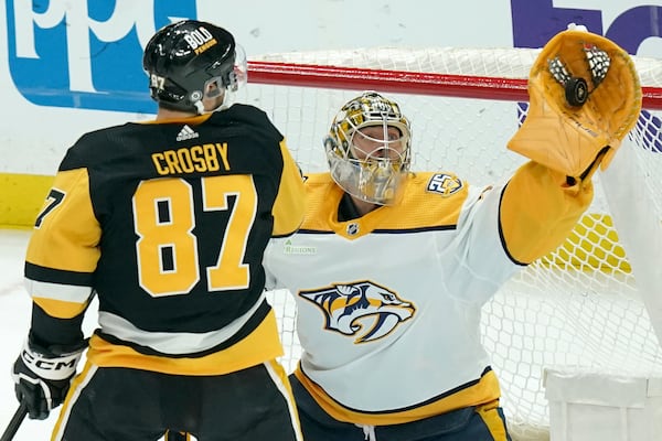 FILE - Nashville Predators goaltender Juuse Saros, right, makes a save in front of Pittsburgh Penguins' Sidney Crosby (87) during the first period of an NHL hockey game, April 15, 2024, in Pittsburgh. (AP Photo/Matt Freed, File)
