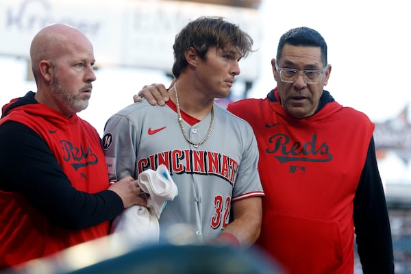 Cincinnati Reds outfielder Tyler Callihan (32) is helped off the field after colliding with the wall during the third inning of a baseball game against the Atlanta Braves, Monday, May 5, 2025, in Atlanta. (AP Photo/Butch Dill)