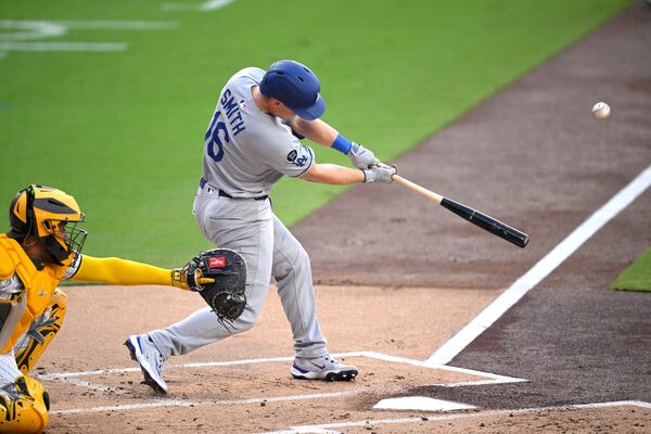 Los Angeles Dodgers' Will Smith (16) hits a sacrifice fly against the San Diego Padres during the first inning of a baseball game Monday, June 9, 2025, in San Diego. (AP Photo/Orlando Ramirez)