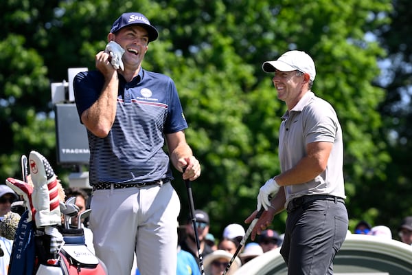 Keegan Bradley, left, shares a light moment with Rory McIlroy, of Northern Ireland, right, as they start the first round of the Travelers Championship golf tournament at TPC River Highlands, Thursday, June 19, 2025, in Cromwell, Conn. (AP Photo/Jessica Hill)