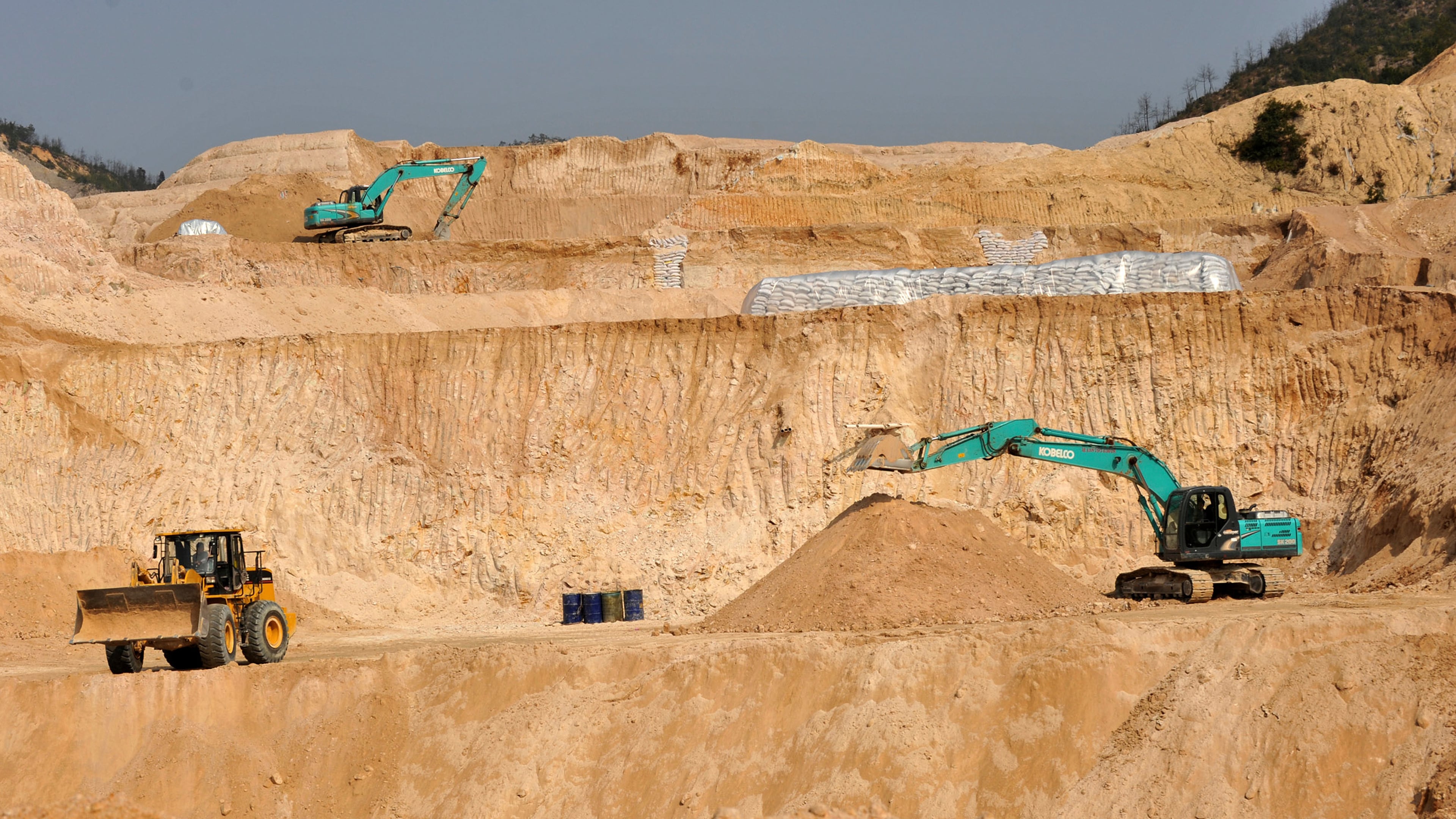 FILE - Workers use machinery to dig at a rare earth mine in Ganxian county in central China's Jiangxi province on Dec. 30, 2010. (Chinatopix via AP, File)