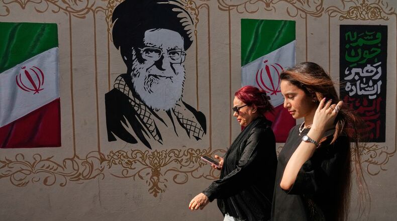 Women walk past a portrait of the late Iranian Supreme Leader Ayatollah Ali Khamenei, who was killed in the U.S. and Israel strike on Feb. 28, and images of the Iranian flag, on a sidewalk in downtown Tehran, Iran, Thursday, Aug. 20, 2026. (AP Photo/Vahid Salemi)