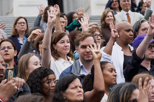 House Democrats on the steps of the Capitol hold up four fingers to signify how many Republicans are needed to vote against President Donald Trump's signature bill of tax breaks and spending cuts, in Washington, Wednesday, July 2, 2025. (AP Photo/J. Scott Applewhite)
