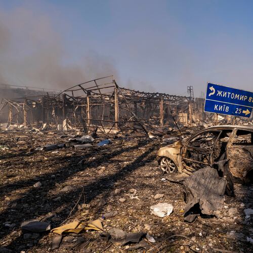 A view of a destroyed car amid damaged buildings, with a road sign showing the direction and distance to Kyiv and Zhytomyr after a Russian attack struck a warehouse, followed by an explosion, in the village of Myla, Kyiv region, Ukraine, Saturday, Aug. 29, 2026. (AP Photo/Dan Bashakov)
