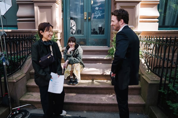 This image released by A24 shows Celine Song, from left, Dakota Johnson, and Chris Evans on the set of "Materialists." (A24 via AP)