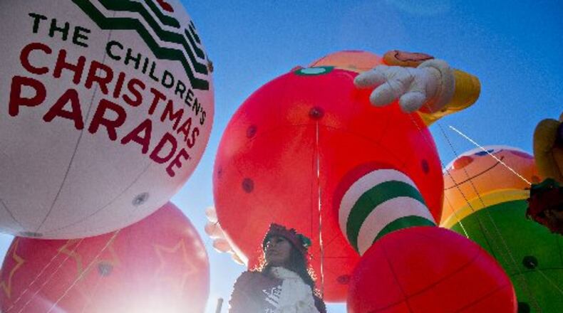 Candace Cashbaugh holds onto a guide wire for one of the giant balloons before the start of the 2015 Children's Christmas Parade in Atlanta on Saturday, December 5, 2015. Thousands gathered along Peachtree St. to watch the parade pass with marching bands, balloons, performances and more. JONATHAN PHILLIPS / SPECIAL