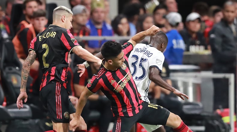 October 24, 2019 Atlanta: Atlanta United players Franco Escobar (left) and Pity Martinez drive around Philadelphia defender Jamiro Monteiro in the Eastern Conference semifinals of the MLS playoffs on Thursday, October 24, 2019, in Atlanta.   Curtis Compton/ccompton@ajc.com