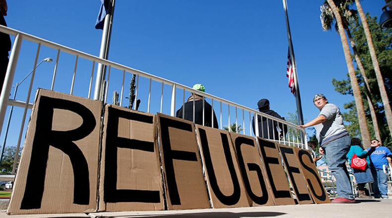 A sign welcoming Syrianrefugees is placed at the entrance to the office of the Arizona governor during a rally at the Arizona Capitol Tuesday, Nov. 17, 2015, in Phoenix. Arizona Gov. Doug Ducey has joined a growing number of governors calling for an immediate halt to the placement of any new refugees in the wake of terrorist attacks in Paris. The U.S. State Department says Arizona has received 153 Syrianrefugees so far this year.