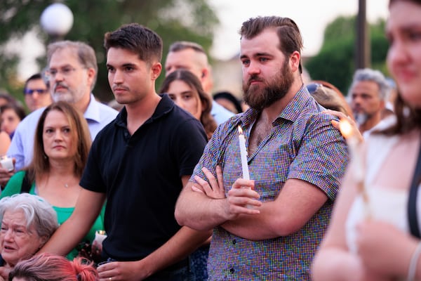 Colin Hortman, right, attends a candlelight vigil for his parents, former House Speaker Melissa Hortman and her husband Mark, who were fatally shot, at the state Capitol, Wednesday, June 18, 2025, in St. Paul, Minn. (AP Photo/Nikolas Liepins)