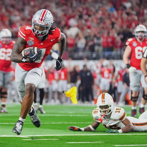 FILE - Ohio State wide receiver Jeremiah Smith, center, gets away from Miami defensive lineman David Blay Jr. (11) and defensive back Ja'Boree Antoine (16) to score a touchdown during the second half of the Cotton Bowl College Football Playoff quarterfinal game Wednesday, Dec. 31, 2025, in Arlington, Texas. (AP Photo/Julio Cortez, File)