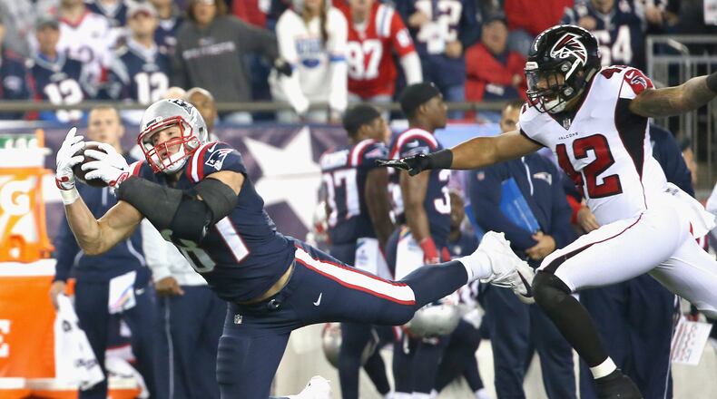 Rob Gronkowski of the Patriots makes a diving catch as he is defended by Duke Riley of the Falcons during  Sunday’s game.  The catch was reversed due to offensive pass interference.
