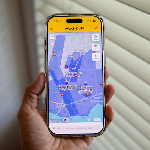 A person uses the Watch Duty app to track floods, Thursday, June 18, 2026, in San Diego, Calif. (AP Photo/Gabriela Aoun Angueira)