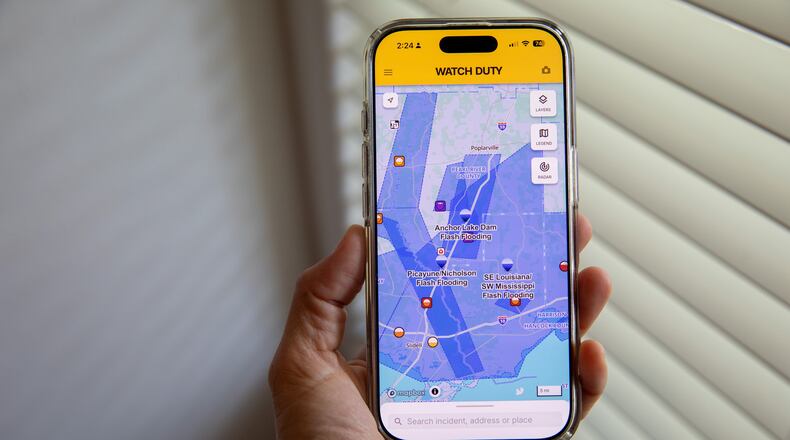A person uses the Watch Duty app to track floods, Thursday, June 18, 2026, in San Diego, Calif. (AP Photo/Gabriela Aoun Angueira)