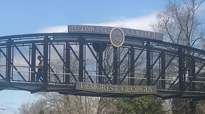 A man walks across the bridge connecting portions of Piedmont College’s main campus in Habersham County. ERIC STIRGUS / ESTIRGUS@AJC.COM