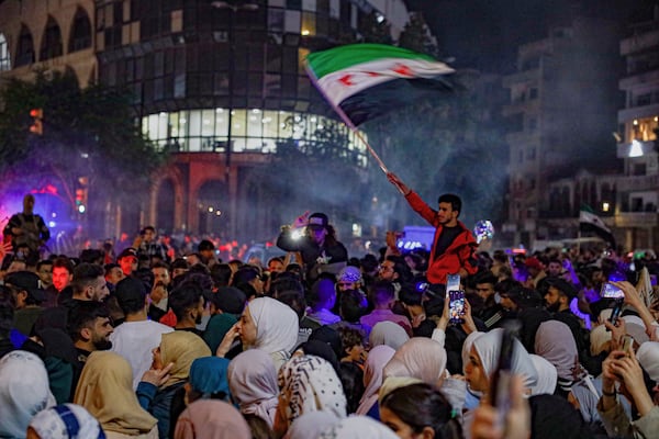 Syrians celebrate after U.S. President Donald Trump announced plans during his visit to Saudi Arabia to ease sanctions on Syria and normalize relations with its new government, in Homs, Syria, late Tuesday, May 13, 2025.(AP Photo/Omar Albam)