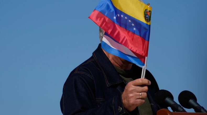 Cuban President Miguel Diaz-Canel waves Venezuelan and Cuban national flags during a rally in Havana, Saturday, Jan. 3, 2026, in solidarity after the U.S. captured President Nicolas Maduro and flew him out of Venezuela. (AP Photo/Ramon Espinosa)