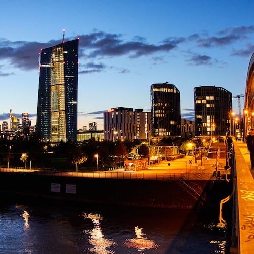 People walk over a bridge near the European Central Bank in Frankfurt, Germany, Sunday, Oct. 26, 2025. (AP Photo/Michael Probst)