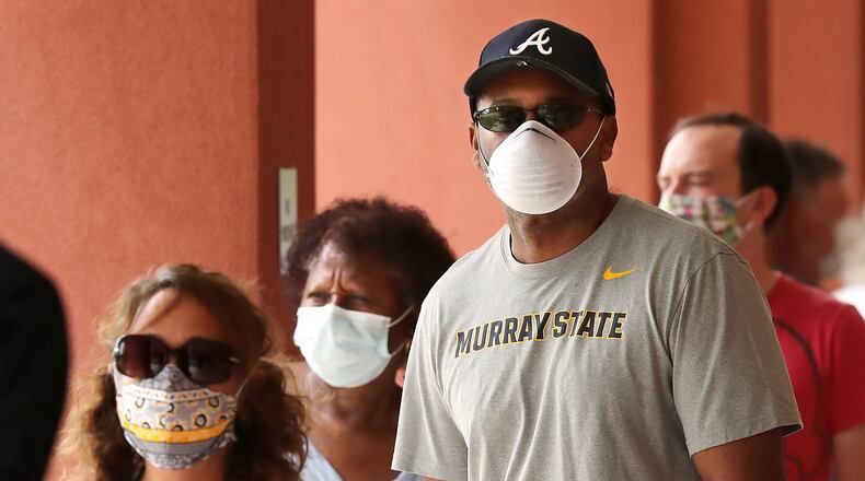 Voters wear masks while lining up to cast their votes during the first day of early voting at the Cobb County Board of Elections & Registration on Monday afternoon, May 18, 2020, in Marietta. Curtis Compton ccompton@ajc.com