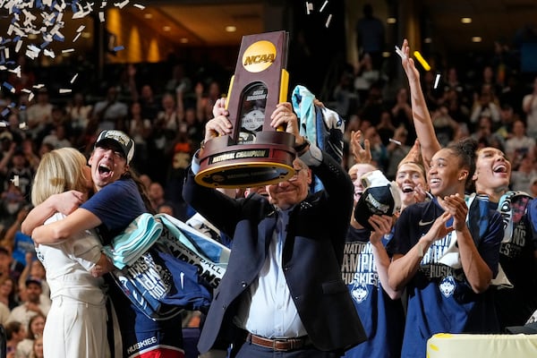 UConn head coach Geno Auriemma holds up the championship trophy after UConn defeated South Carolina in the national championship game at the Final Four of the women's NCAA college basketball tournament, Sunday, April 6, 2025, in Tampa, Fla. (AP Photo/Chris O'Meara)