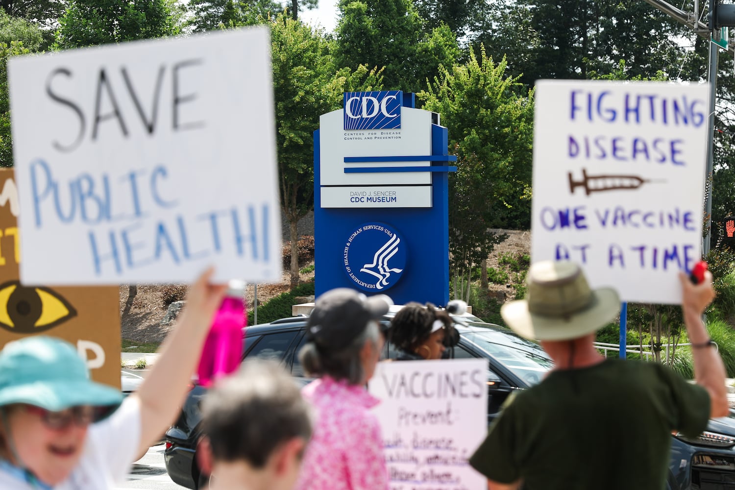 Protestors hold signs outside of the CDC in Atlanta on Wednesday, June 25, 2025. As Health and Human Services Secretary Robert F. Kennedy Jr. purged and reconstituted CDC vaccine advisory panel, ACIP, convenes for the first time, CDC advocates gather to protest on the dangers to health. (Abbey Cutrer / AJC)