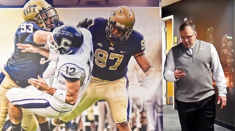 Pitt head coach Pat Narduzzi checks his phone during National Signing Day on Feb. 1, 2017 at the team's facility. College football recruiting nowadays is much more than phones and fax machines. (Matt Freed/Post-Gazette)