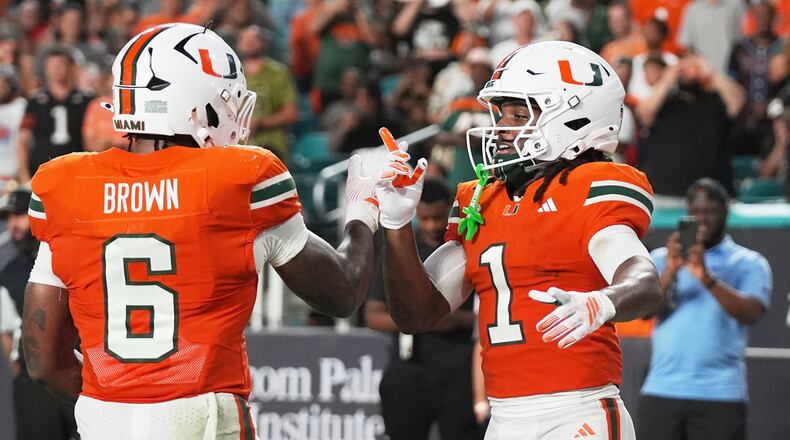 Miami wide receiver Malachi Toney (1) celebrates with running back Charmar Brown (6) after scoring a touchdown during the first half of an NCAA college football game against Florida A&M, Thursday, Sept. 10, 2026, in Miami Gardens, Fla. (AP Photo/Lynne Sladky)
