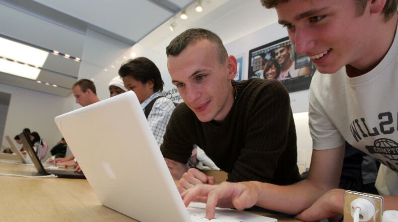 Customers at the Apple Store try out a new MacBook laptop computer July 19, 2006 in San Francisco, California.