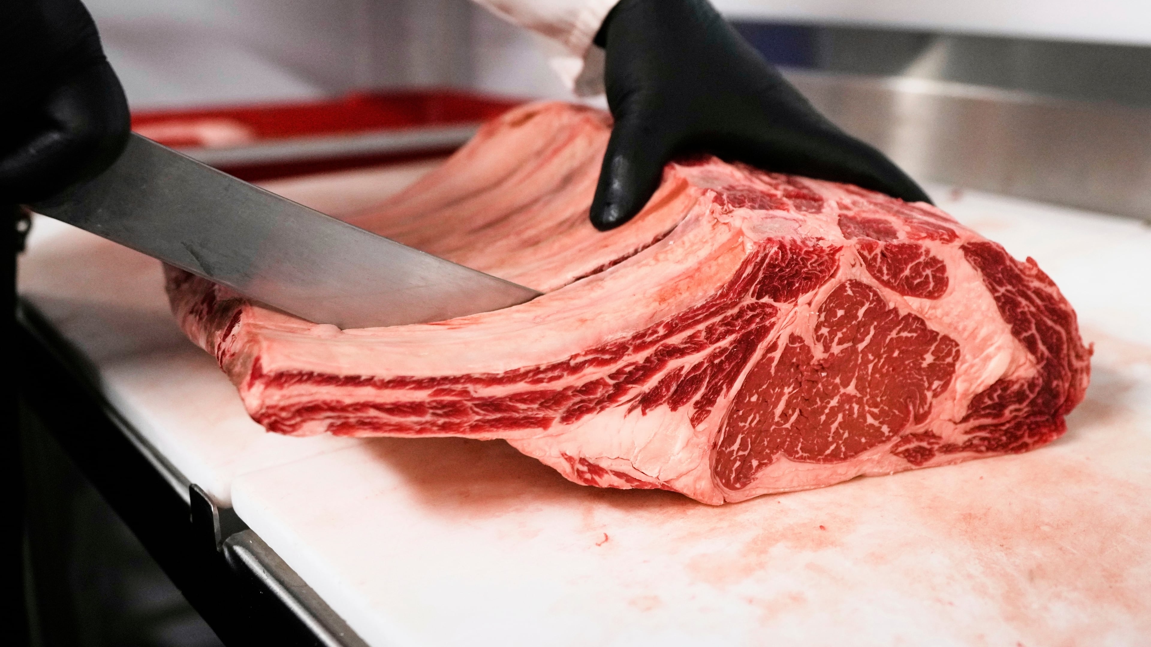 FILE - Raul Rubero, lead butcher at Deep Cuts butcher shop cuts single portions of bone-in steaks as he breaks down a side of beef, Wednesday, Aug. 27, 2025, in Dallas. (AP Photo/Tony Gutierrez, File)