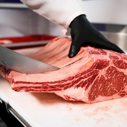 FILE - Raul Rubero, lead butcher at Deep Cuts butcher shop cuts single portions of bone-in steaks as he breaks down a side of beef, Wednesday, Aug. 27, 2025, in Dallas. (AP Photo/Tony Gutierrez, File)