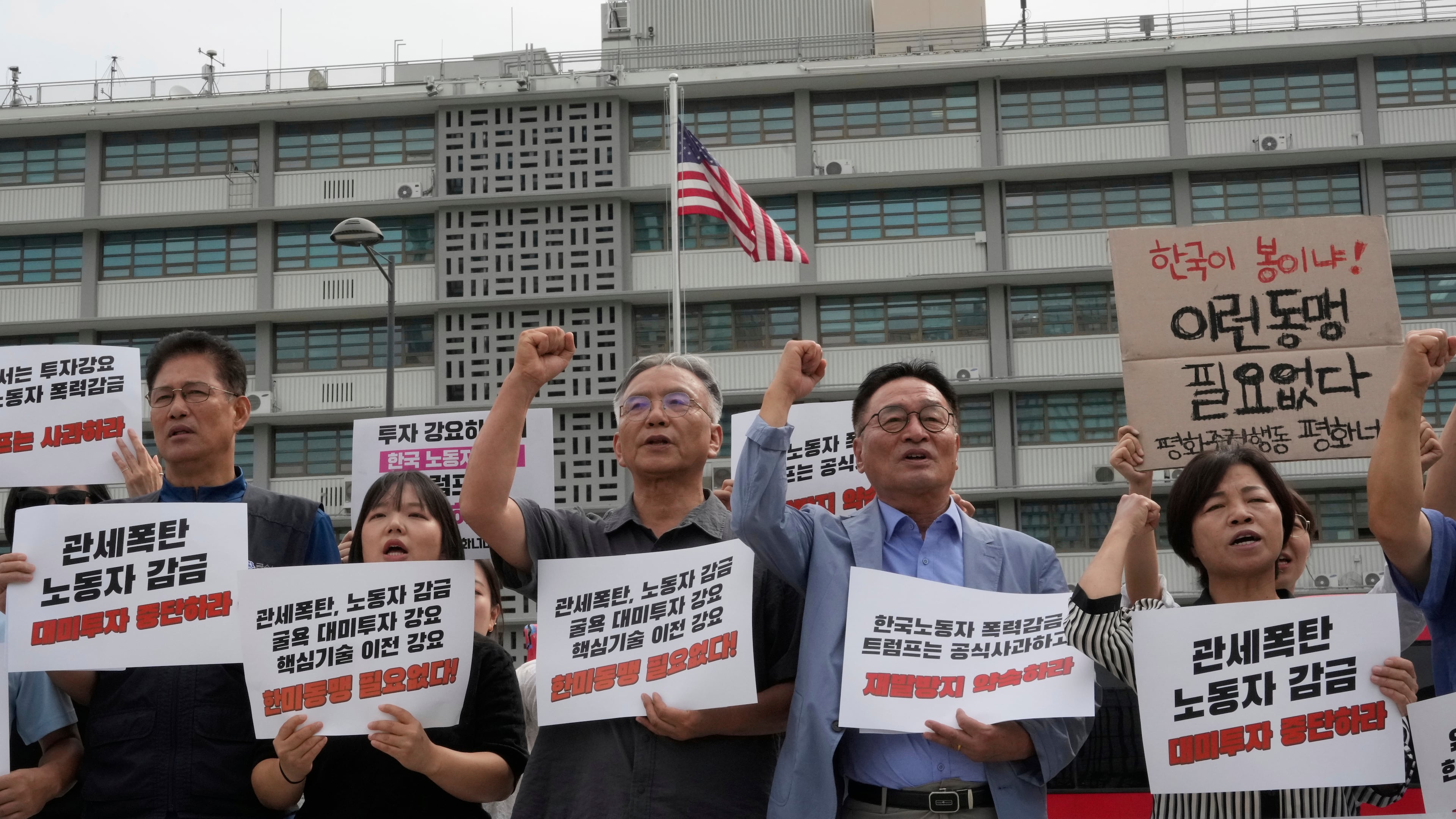 Protesters stage a rally against the detention of South Korean workers during an immigration raid in Georgia, near the U.S. Embassy in Seoul, South Korea, Tuesday, Sept. 9, 2025. The signs read "A tariff bomb and workers confinement." (AP Photo/Ahn Young-joon)