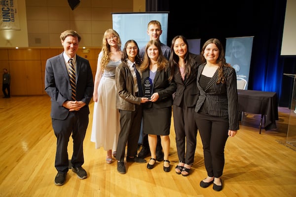 From left, students Luke Calhoun, Olivia Beazer, Sona Zarkou, Mae Bradford, front, Lincoln Bradford, back, Cindy Huang and Juliana Migliati from Arizona's BASIS Flagstaff Charter School pose with the first place trophy after winning the National High School Ethics Bowl in Chapel Hill, N.C., on Sunday, April 13, 2025. (AP Photo/Allen G. Breed)