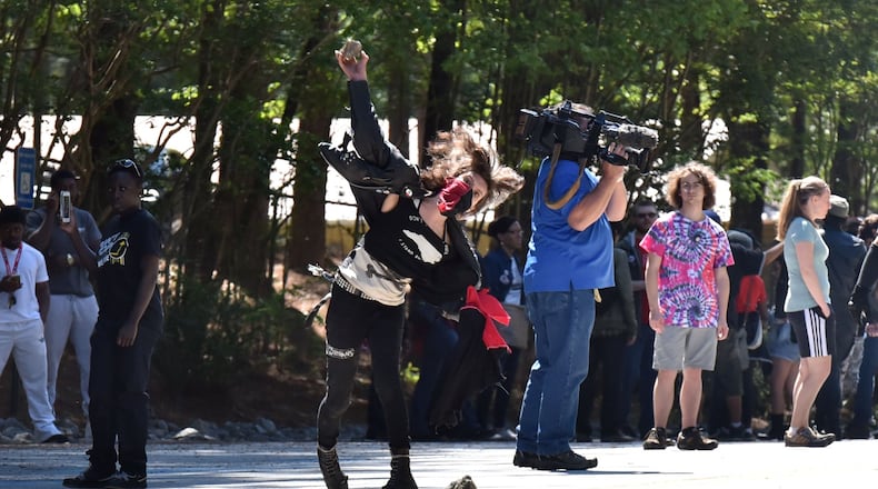 April 23, 2016 Stone Mountain - A counter-protester throws a rock at police during a clash at Stone Mountain Park on Saturday, April 23, 2016. Violent protests surrounding a white power rally at Stone Mountain have caused officials to shut down public attractions at the park. HYOSUB SHIN / HSHIN@AJC.COM
