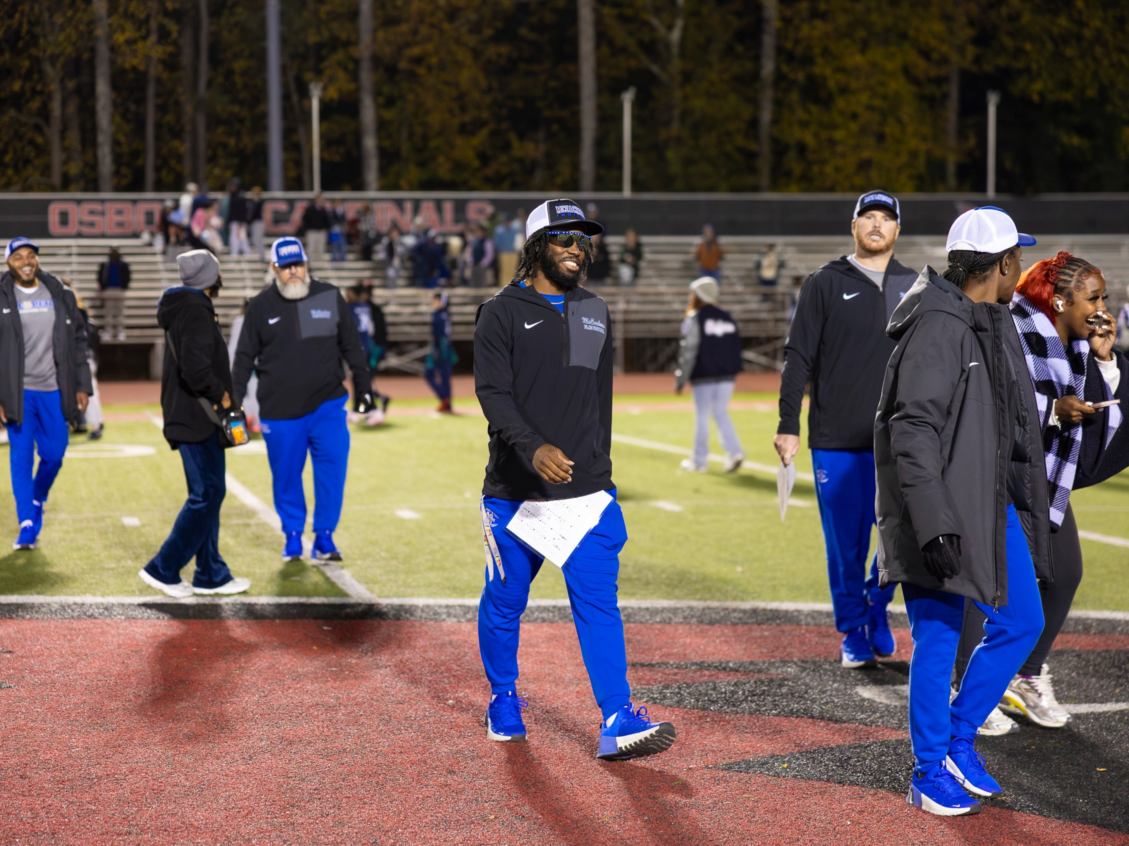 McEachern assistant coach and former "Freeze" Atlanta Braves runner Nigel Talton smiles at his coaching staff during a flag football playoff game against Marietta at Osborne High School in Marietta, GA on Monday, November 17th, 2025. (Oscar Guevara Saenz for the AJC)