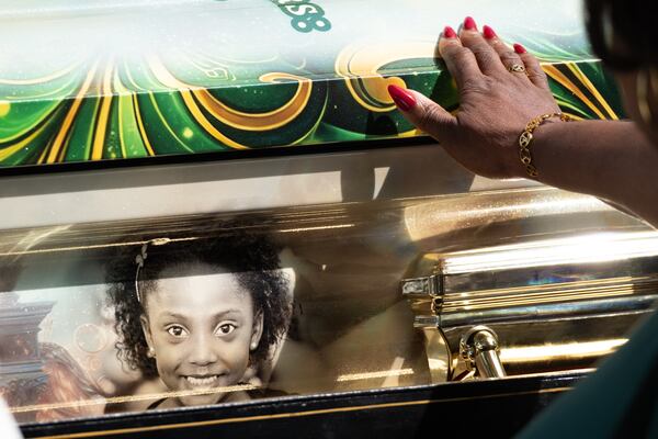 A woman touches Tianah Robinson’s casket following a celebration of life at Ebenezer Baptist Church in Atlanta on Saturday, April 18, 2026. Robinson was the 16-year-old who was killed during a shooting at Piedmont Park on following 404 Day celebrations. (Ben Gray for the AJC)
