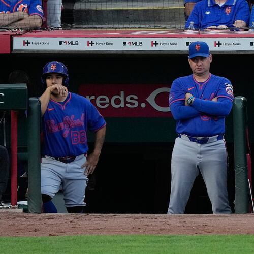 New York Mets manager Carlos Mendoza center, looks out from the dugout during the fourth inning of a baseball game against the Cincinnati Reds in Cincinnati, Monday, June 15, 2026. (AP Photo/Carolyn Kaster)