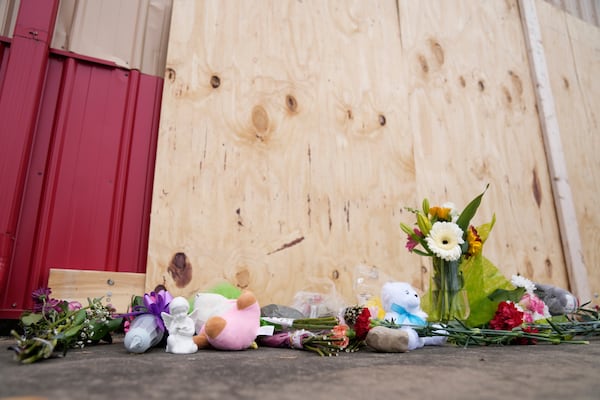 Flowers and other gifts are left at the scene after a car barreled through a building used for an after-school camp Tuesday, April 29, 2025, in Chatham, Ill. (AP Photo/Erin Hooley)