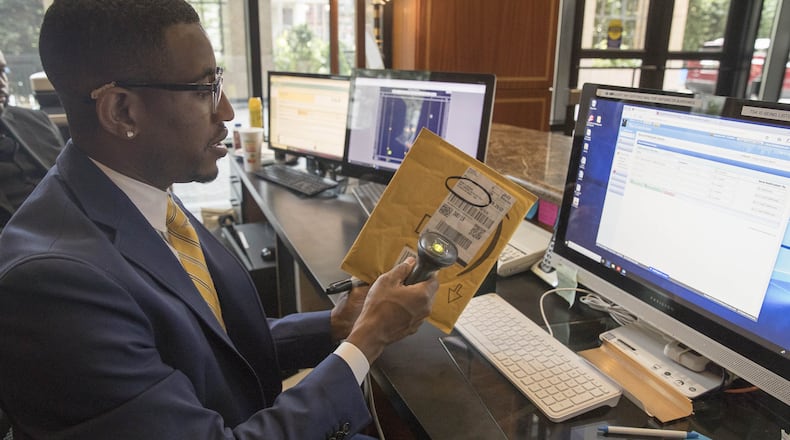 Front desk manager Emmy Marshall scans packages into the system at the Grandview condominiums in Atlanta’s Buckhead community. (ALYSSA POINTER/ALYSSA.POINTER@AJC.COM)